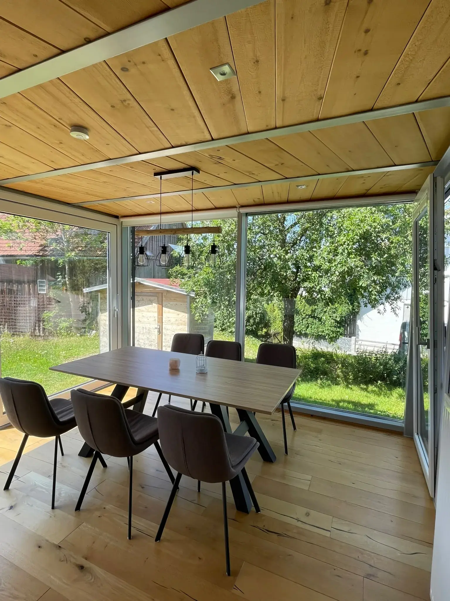 Essbereich im Wintergarten der Ferienwohnung Klärle in Leutkirch im Allgäu mit großem Gartenblick